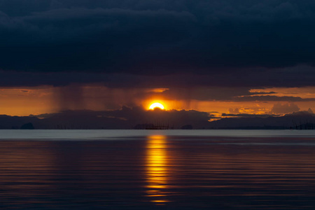 日落天空和雨云的海景。