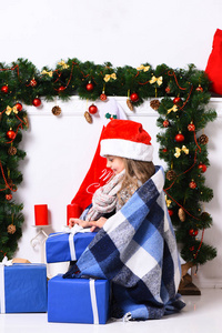 圣诞老人小姐在红帽和蓝色毯子打开礼物