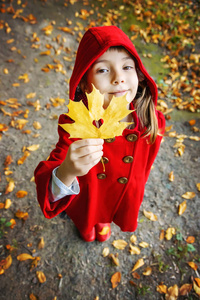 穿着红色外套和秋叶的孩子。 爱秋天。 选择性聚焦。 大自然。