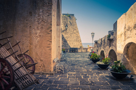 s castle on rock Castello Ruffo with stone ancient walls, street