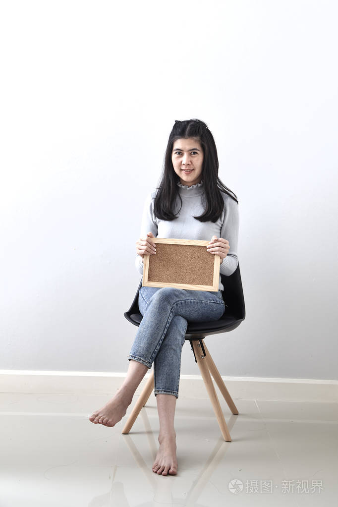 美丽的年轻亚洲妇女公告板,内脏,姿势,姿态,坐在椅子上的白色墙壁背景