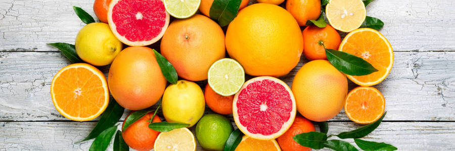 新鲜柑橘水果背景。 橘子柚子柠檬酸橙橘子。 将柑橘类水果与叶子混合。 长网页格式