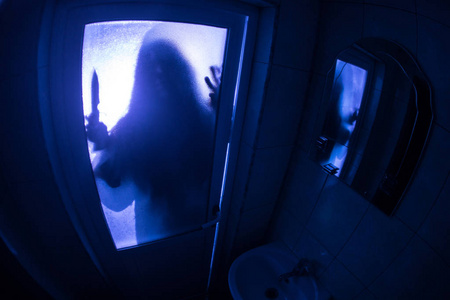 窗户里女人的恐怖剪影. 可怕的万圣节概念模糊的女巫在浴室的剪影照片