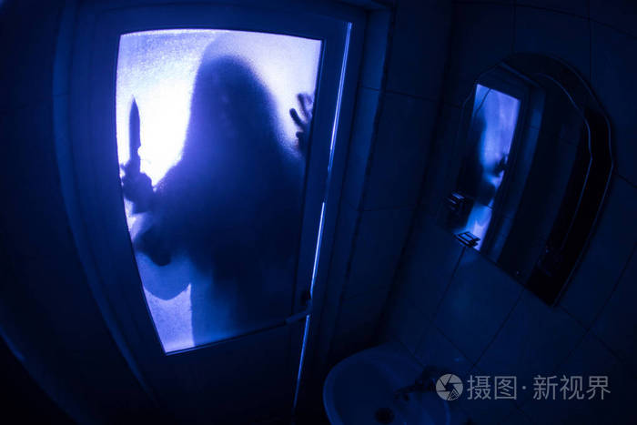 窗户里女人的恐怖剪影. 可怕的万圣节概念模糊的女巫在浴室的剪影