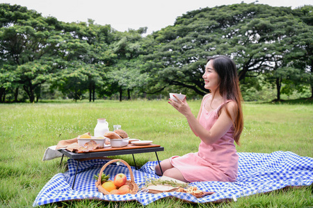 野餐概念。 美丽的女孩在外面度假。 美丽的女孩很高兴休息。