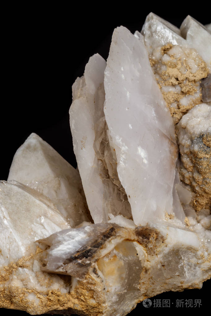 黑色背景下含有方解石的宏观矿物石雪石,石英照片-正版