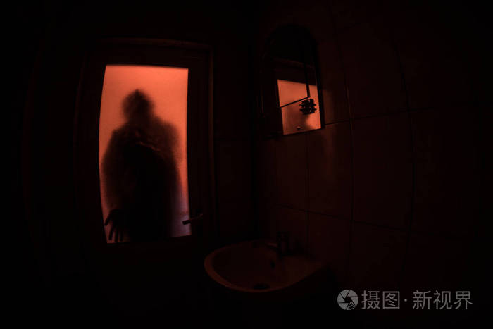 窗户里女人的恐怖剪影. 可怕的万圣节概念模糊的女巫在浴室的剪影
