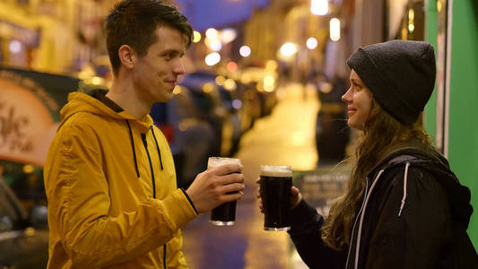 两个朋友在爱尔兰酒吧前喝啤酒