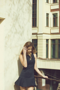 漂亮的女孩，在阳台上的黑色礼服