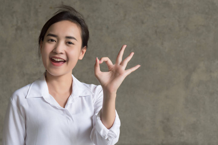 开朗微笑的女人的肖像, 指着批准, 是的, 好, 不错, 拇指向上的手势