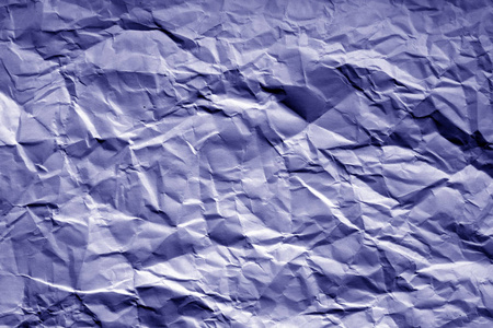 皱巴巴的纸，蓝色色调的模糊效果。 设计的抽象背景和纹理。