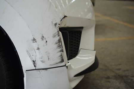 白色汽车前部有破损的划痕照片