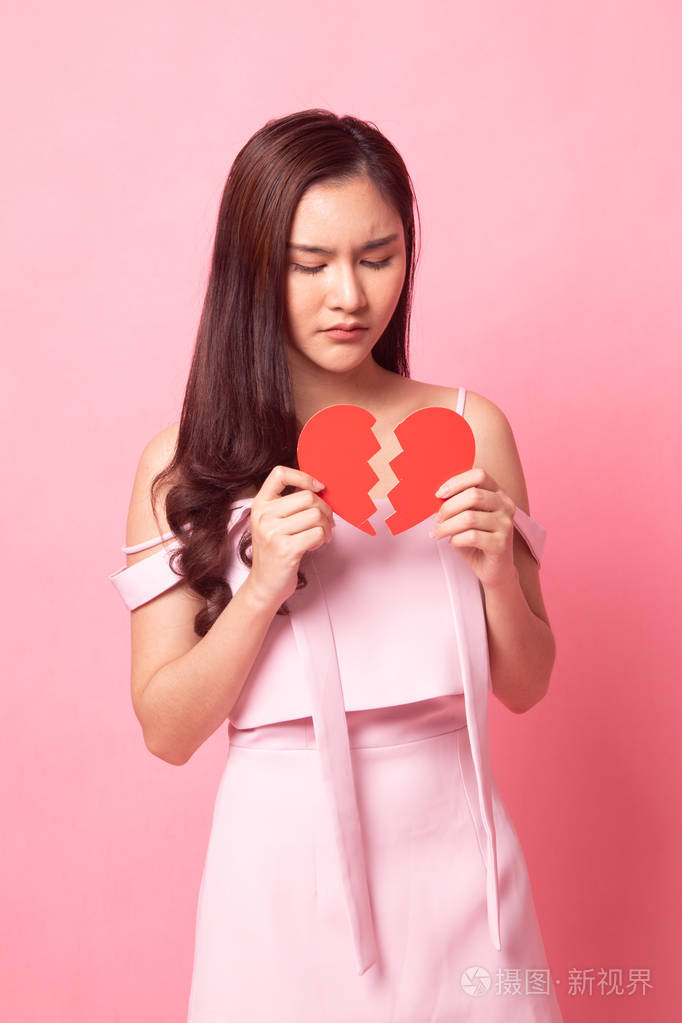 美丽的年轻亚洲女人心碎的粉红色背景