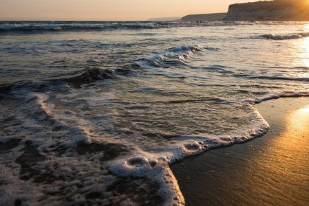 金色夕阳下，海浪逼近沙滩