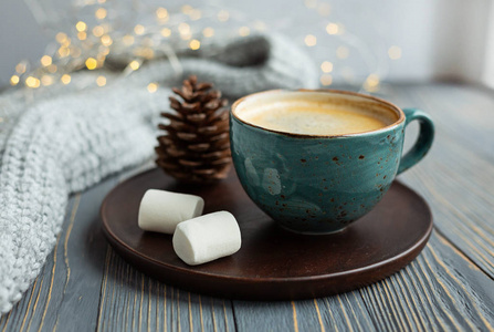 一杯咖啡棉花糖温针织毛衣在木制背景上。 温暖的灯光。 舒适的冬日早晨。 生活方式的概念。 选择性聚焦。
