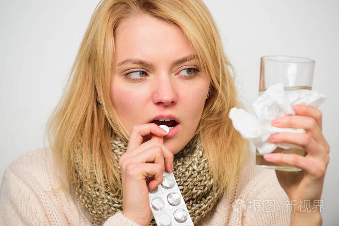 女孩拿药喝水.头痛和感冒疗法照片-正版商用