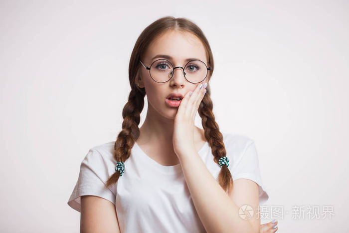 牙齿问题女人觉得牙疼特写美丽悲伤的女孩戴眼镜在白色背景上遭受强烈