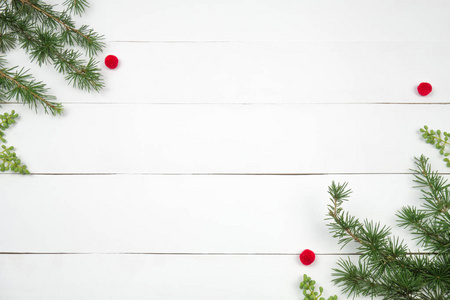 创意圣诞版面。 冷杉树枝和红色毛条。 白色木材背景白色复制空间。 边境安排。 平躺顶部视图。