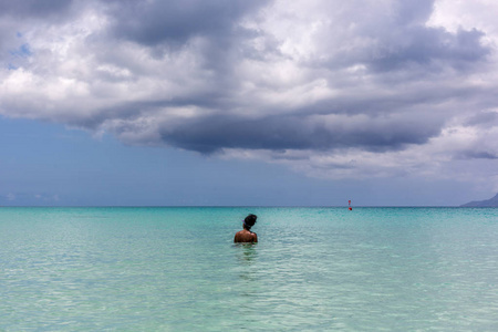 一个黑人孤独的女人在塞舌尔马河岛的海滩上享受平静的水
