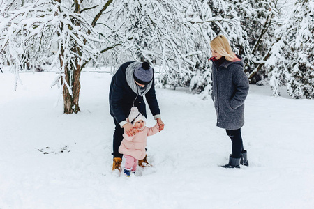 时尚快乐的年轻家庭和宝宝一起散步冬天街头爸爸妈妈孩子