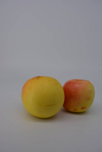 新鲜的，美味的，可食用的，秋天的黄色苹果，红色的桶和红色的点，白色背景的木头，新鲜的水果，新鲜的食物