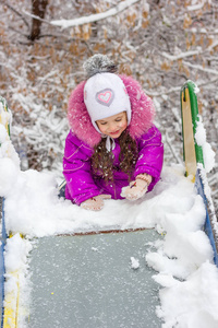 在下雪的冬日，孩子们滑着滑梯