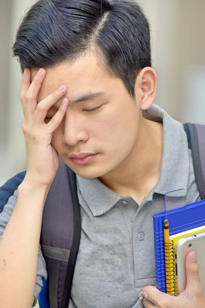 抑郁的男孩学生带着书