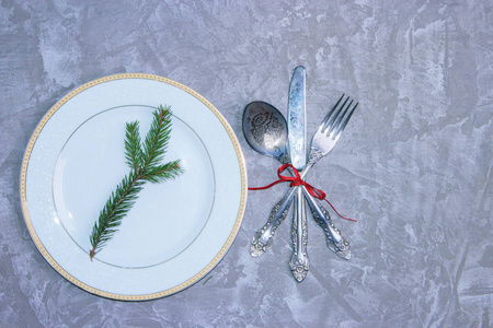 圣诞餐桌设置冷杉枝和红色丝带。 假期背景。