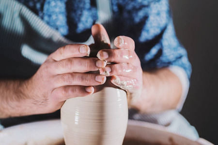 艺术家操作的手，轻轻创造正确形状的手工粘土。 传统制陶教师在艺术工作室展示陶器的基本知识