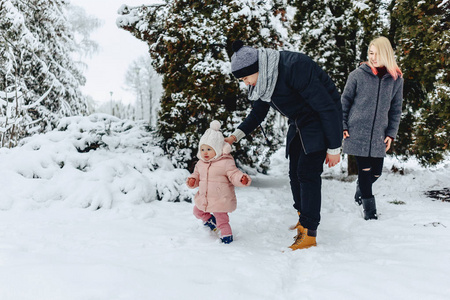 时尚快乐的年轻家庭和宝宝一起散步冬天街头爸爸妈妈孩子