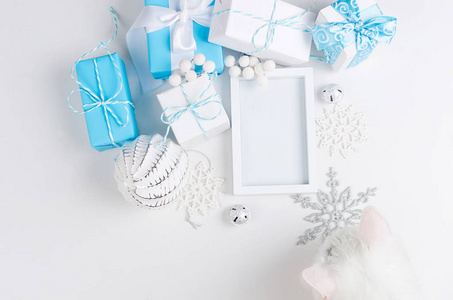 圣诞贺卡，白色空框，蓝色和白色节日装饰球和玩具，白色背景复制空间，顶部视图平躺。