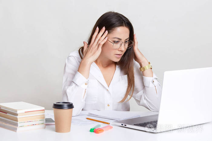 压力重重的女人带着困惑的表情出现在屏幕上,穿着正式的衬衫,忙着做