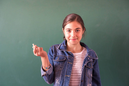 带粉笔的女学生在黑板上的学校生活。