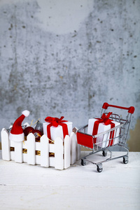 圣诞礼物和装饰品放在一个白色的盒子里，背景是灰色的。 圣诞义卖。