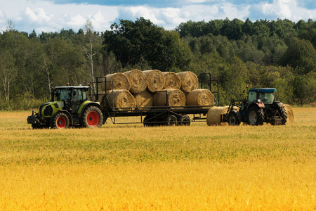 农业装载机在农场上运送一堆干草
