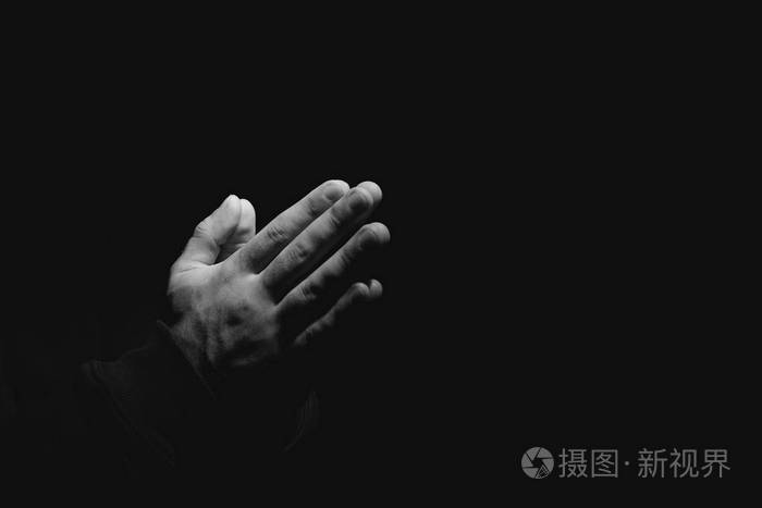 宗教人士的双手在黑暗背景下祈祷黑白效果