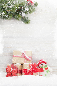 圣诞礼品盒雪人玩具和杉树枝。 为您的问候提供空间
