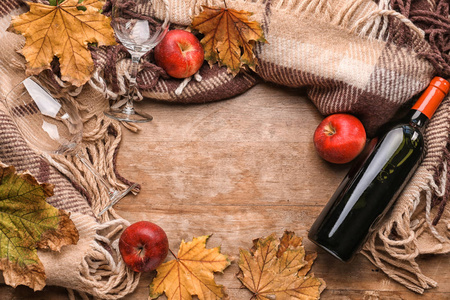 木质背景上的葡萄酒暖格子和秋叶组成