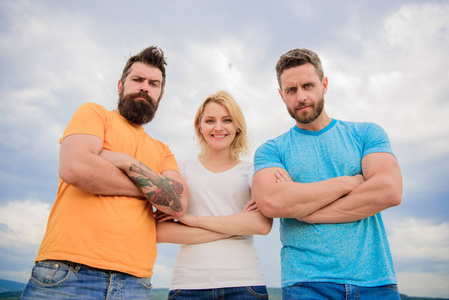 三人自信地站在折叠的胳膊.三人行看着你.凝聚力团队的行为.