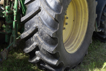 在六月的阳光明媚的一天，在德国南部的农村，你看到机器车轮和农舍设备的一部分用于收割和农业工作。