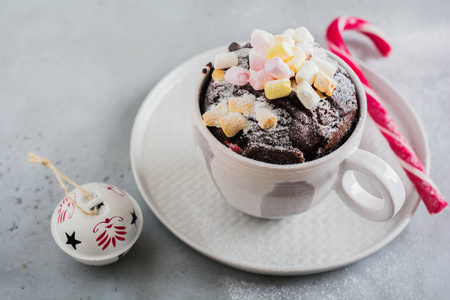 s chocolate cake cooked in microwave oven in mug on vintage gray