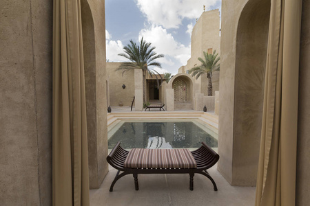 迪拜酒店的游泳池，有长凳和棕榈树