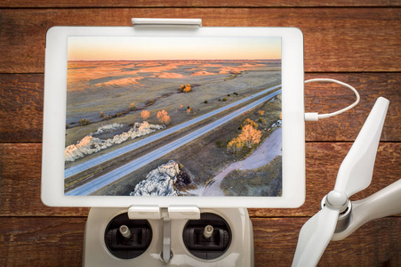 高速公路I25穿过科罗拉多州北部的滚动草原，在安装在无人机无线电控制器上的数字平板电脑上查看空中图像
