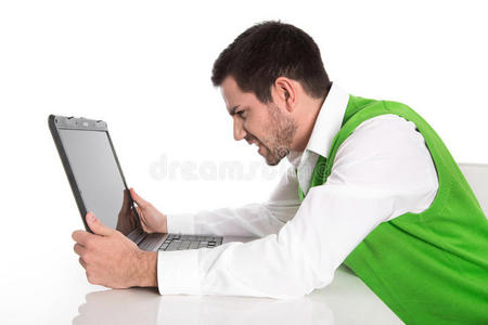 一个孤独沮丧的商人，桌上放着一台白色的笔记本电脑。