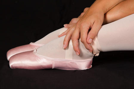 女舞者穿着粉色芭蕾短裙坐在地板上看起来很悲伤