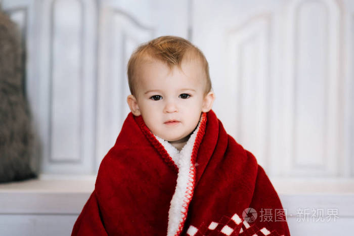 美丽的小男孩在圣诞节装饰的背景上红色。 圣诞快乐，新年理念