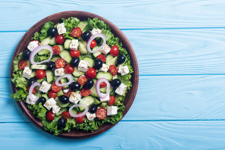 新鲜蔬菜希腊沙拉。 木制背景的健康食品