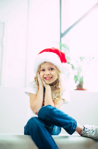 戴着圣诞帽的微笑女孩在镜头前摆姿势
