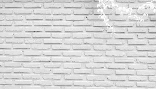白色和灰色砖墙纹理背景与空间的文本。 白色砖块壁纸。 家庭内部装饰。 砖墙上常春藤的白色叶子。 建筑概念。