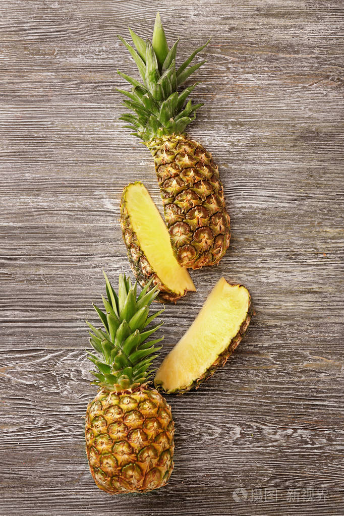 木制背景上整块切熟的菠萝照片-正版商用图片13wg3m-摄图新视界